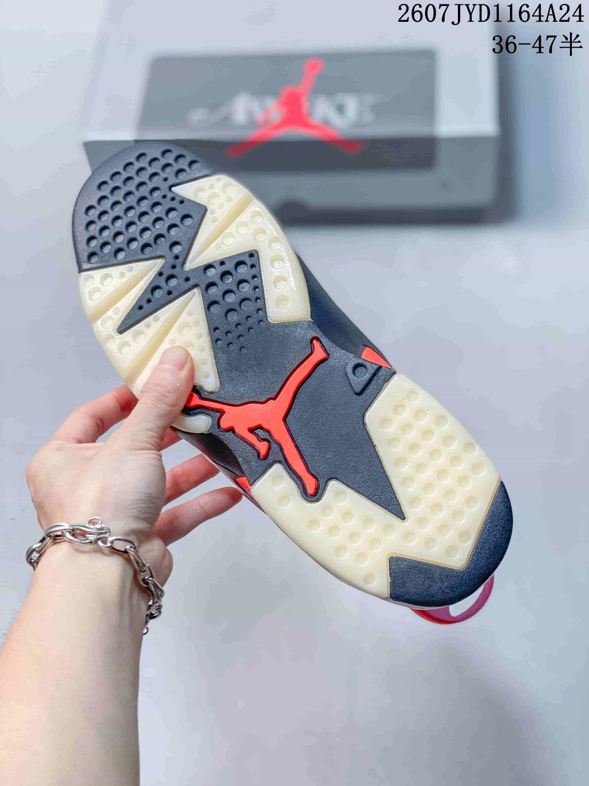 Underside view of the sneaker showing a black, cream and red patterned outsole with circular traction details.