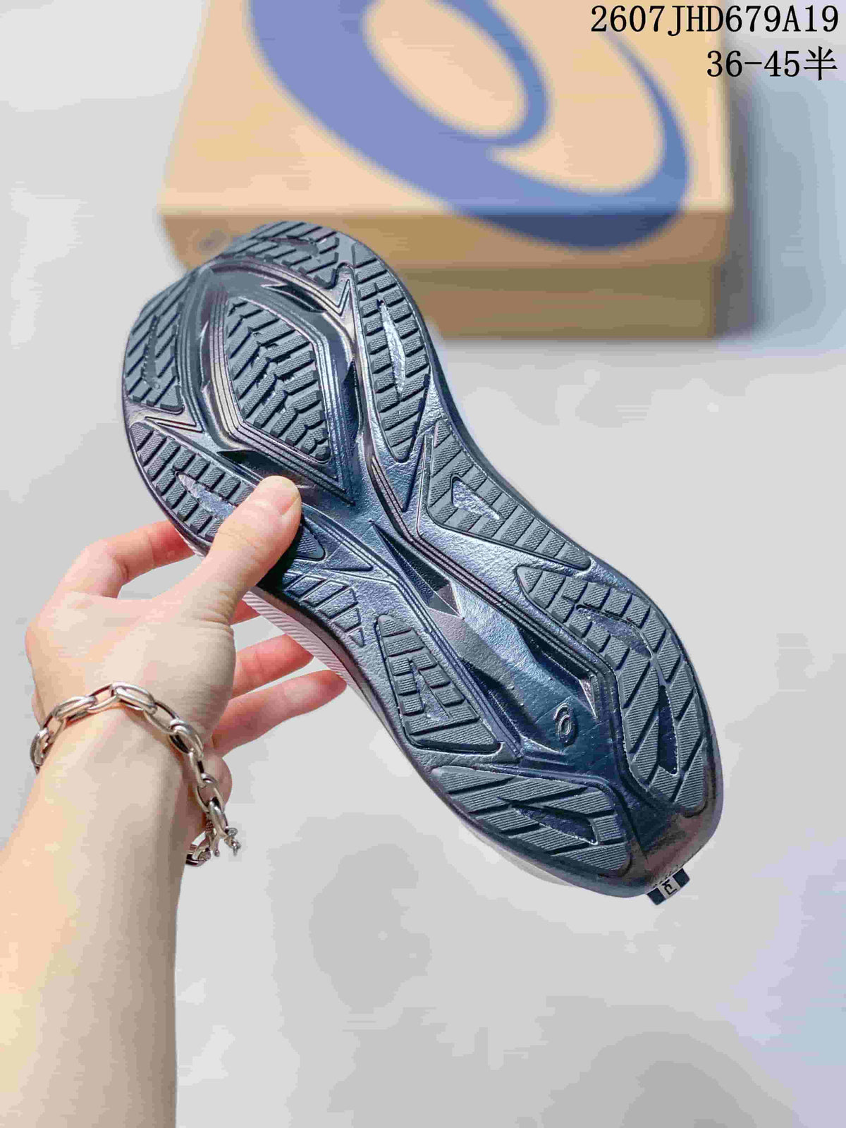 Underside view showing the black patterned outsole and traction grooves of an ASICS running sneaker.