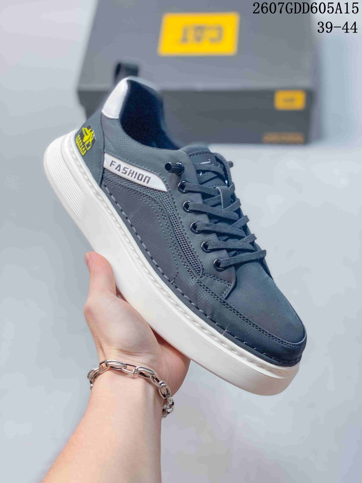 Close-up side view of a charcoal CAT sneaker with stitched panels, lace-up closure and white outsole.