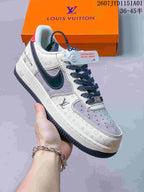 Angled side view of a cream and gray patterned sneaker with dark side detail, red heel tab, and orange box.