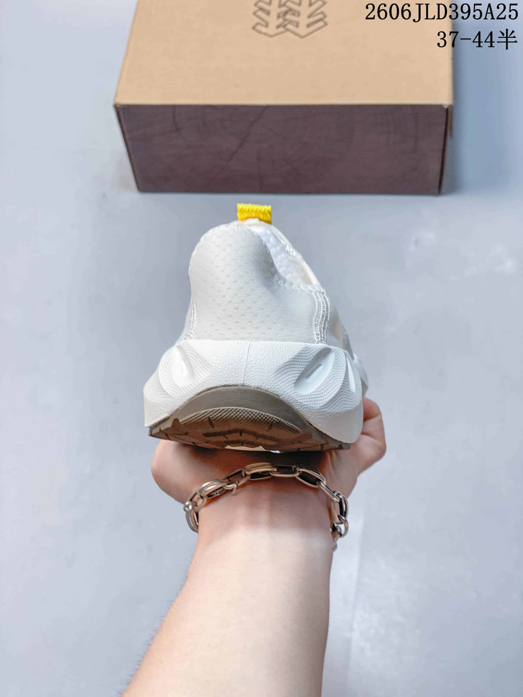 Rear view of the white slip-on shoe showing its heel and sole.
