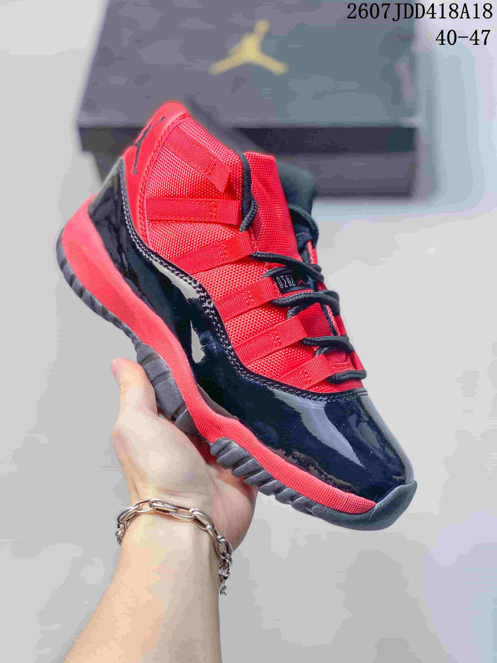 Angled side view of a single black and red high-top sneaker with glossy lower panels and red accents.