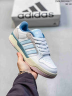Angled side view of the white and light blue adidas Entrap sneaker with layered side stripes and textured outsole.