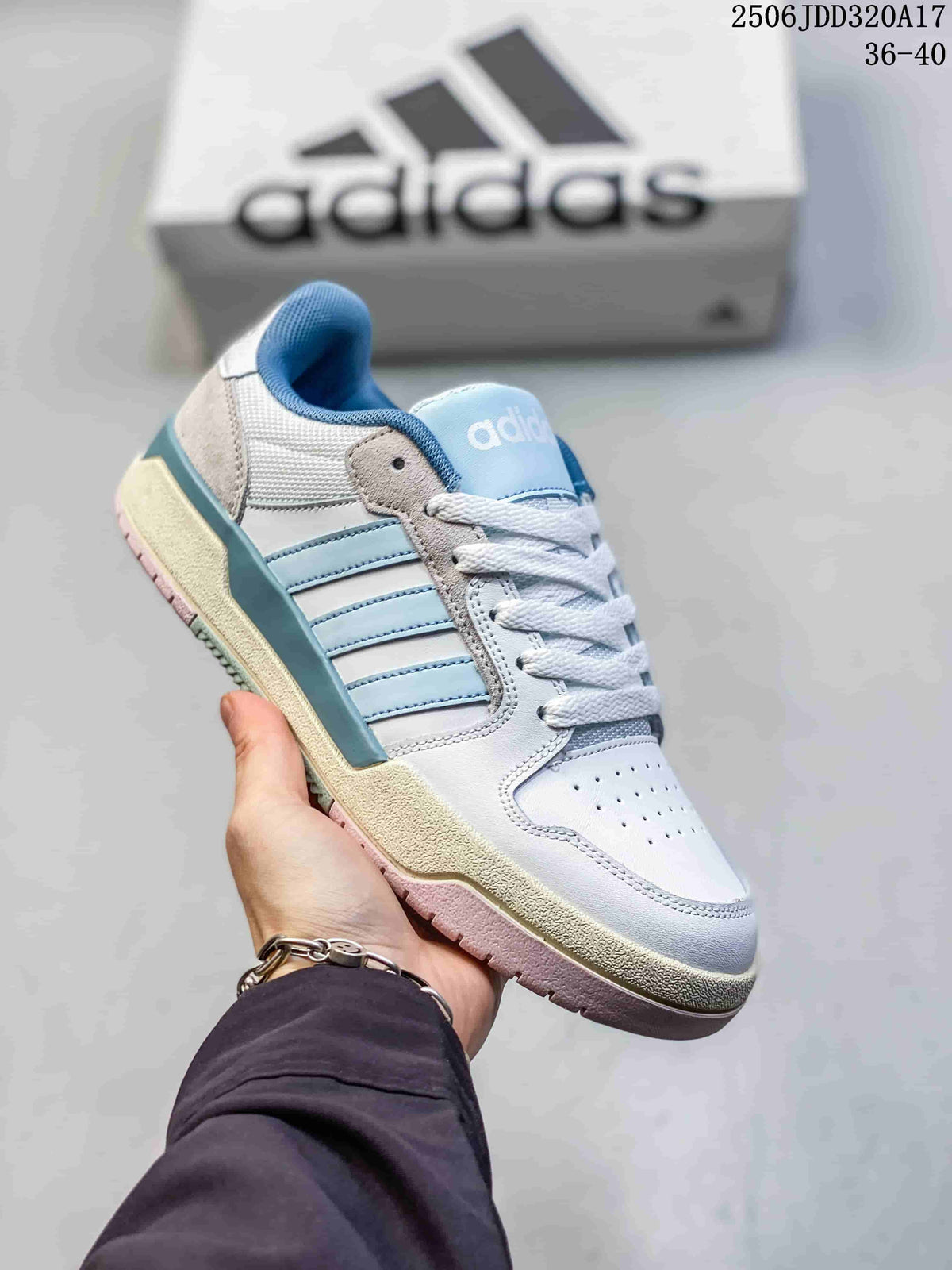 Angled side view of the white and light blue adidas Entrap sneaker with layered side stripes and textured outsole.