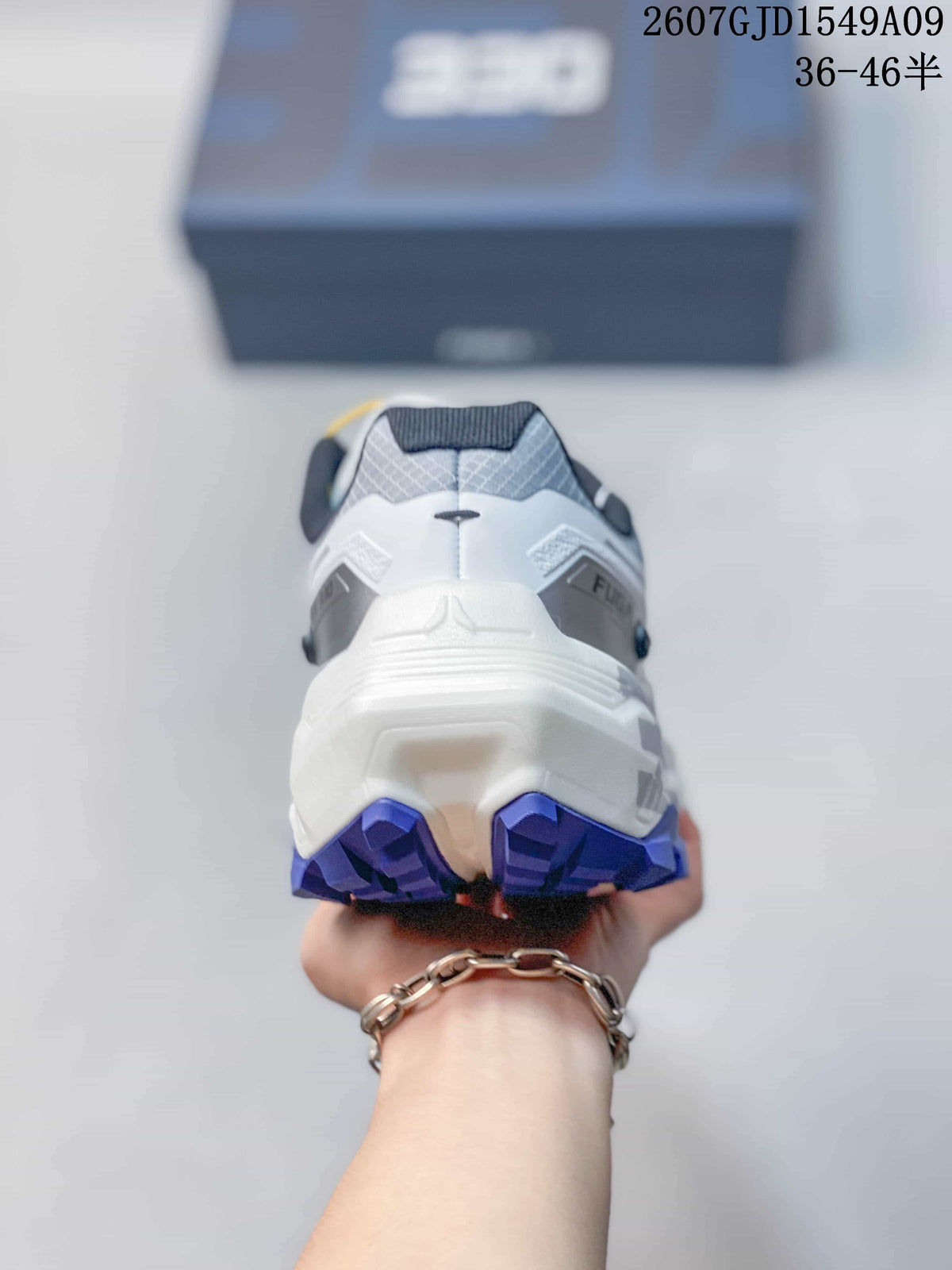 Rear view showing the padded heel, structured white midsole, and purple outsole lugs.