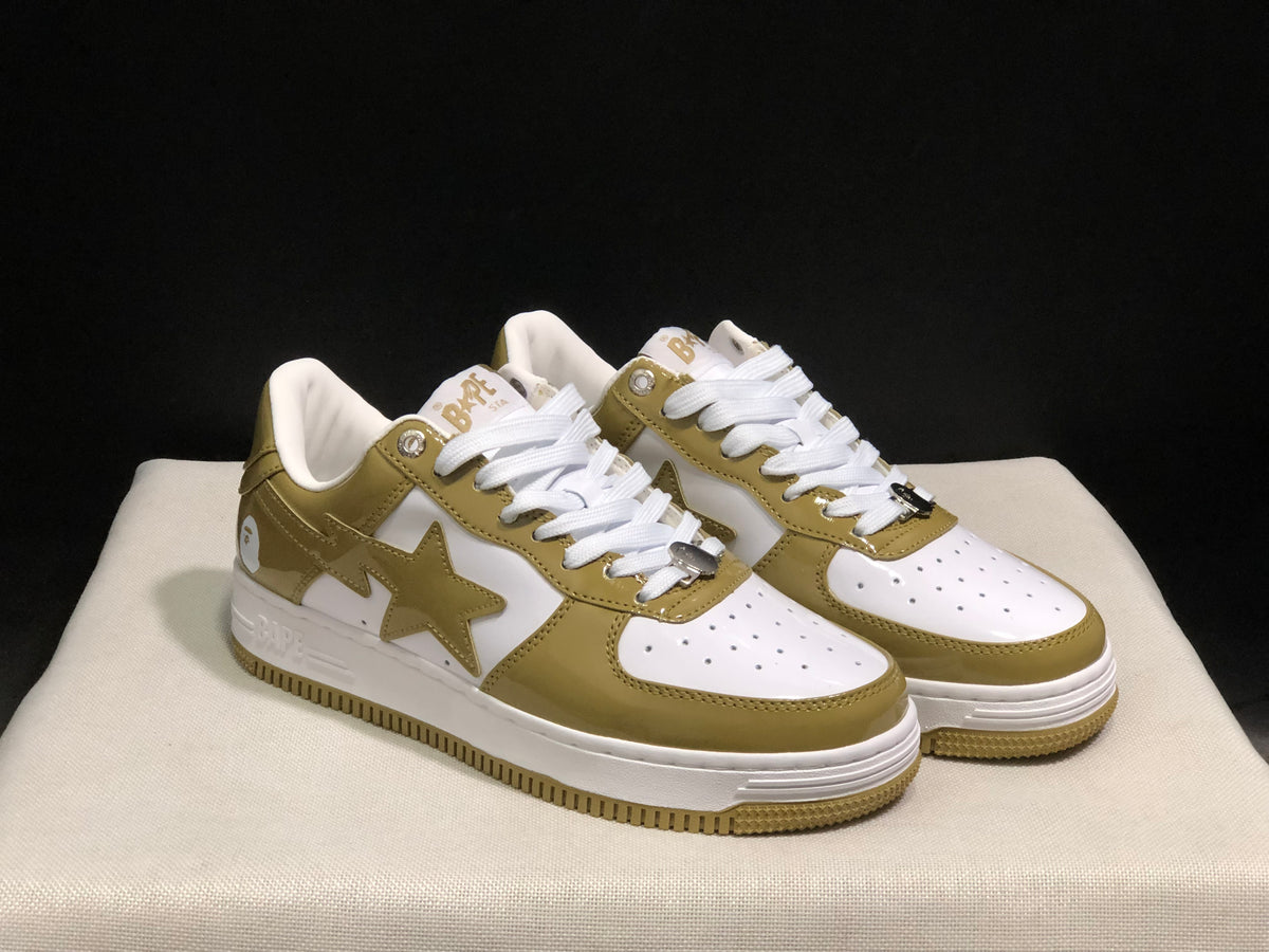 Three-quarter front view of the olive and white BAPE STA sneaker pair with white laces and star side details.