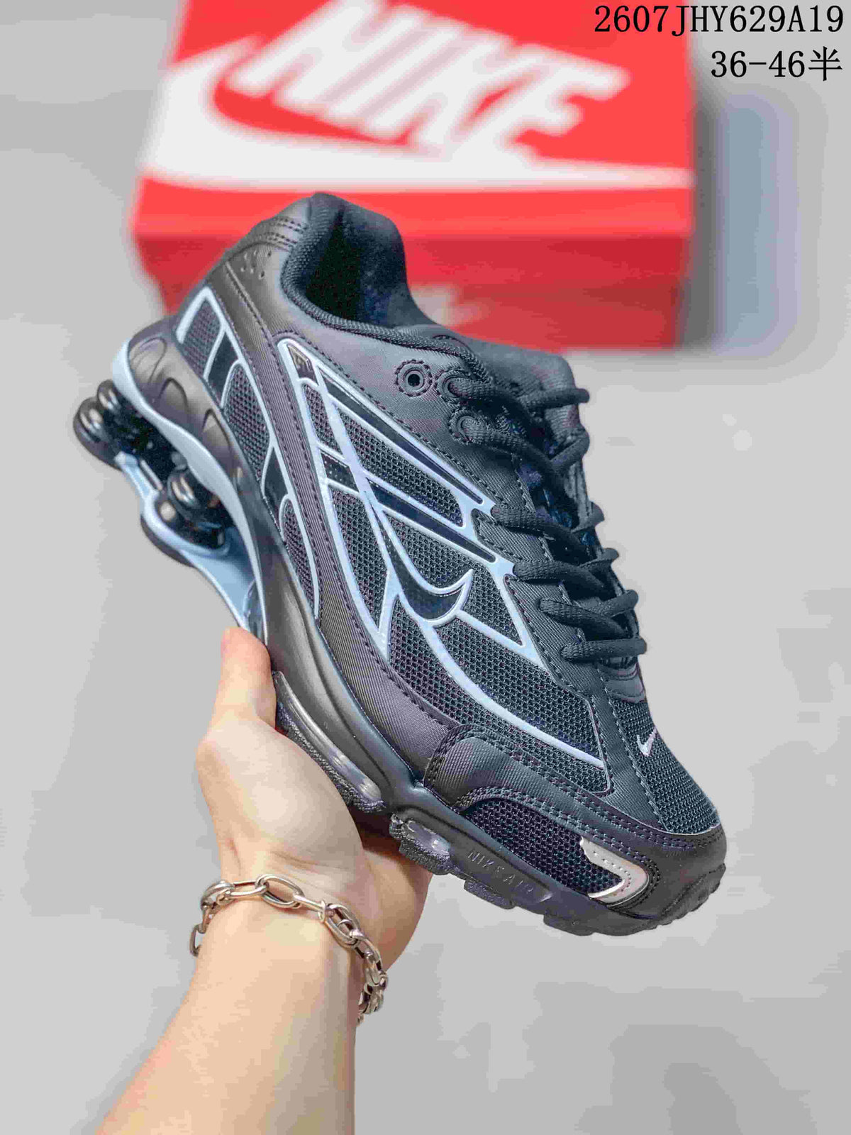 Angled side view of the black and gray sneaker with layered panels and heel columns.