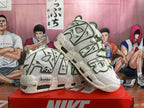 Pair of off-white Nike Air More Uptempo sneakers showing bold side lettering, bamboo graphics, and panda details.