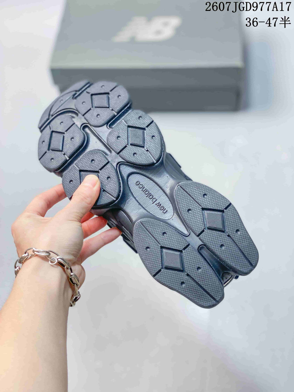 Underside view of a New Balance 9060 sneaker showing the segmented rubber outsole tread and central New Balance branding.