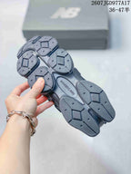 Underside view of a New Balance 9060 sneaker showing the segmented rubber outsole tread and central New Balance branding.