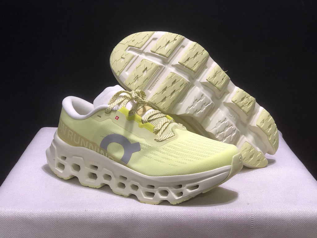 Three-quarter view of the sneakers with one shoe lifted to show the segmented outsole.