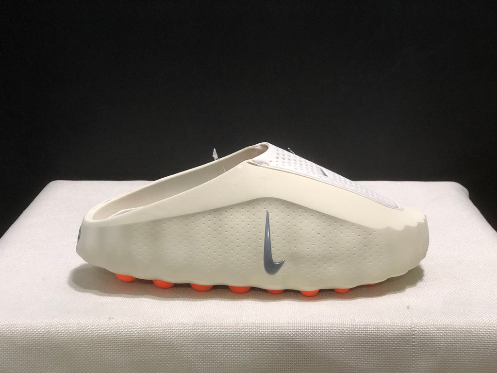 Side profile of a single light bone mule with the grey Swoosh and orange outsole pods visible.