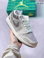 Angled view of the sneaker showing its grey panels, speckled Swoosh and detachable charm