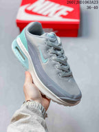 Close side view showing the gray and turquoise color combination, lace-up construction, and visible rear air unit.