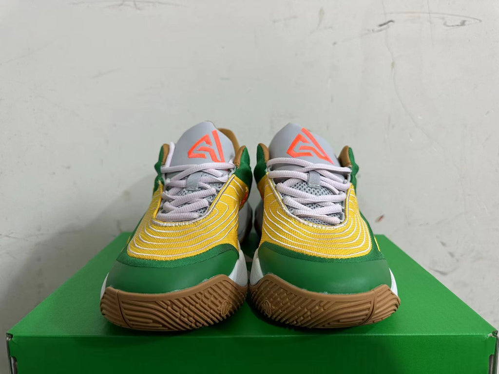 Front view of green and yellow Nike basketball shoes with pale gray laces and orange tongue logos.