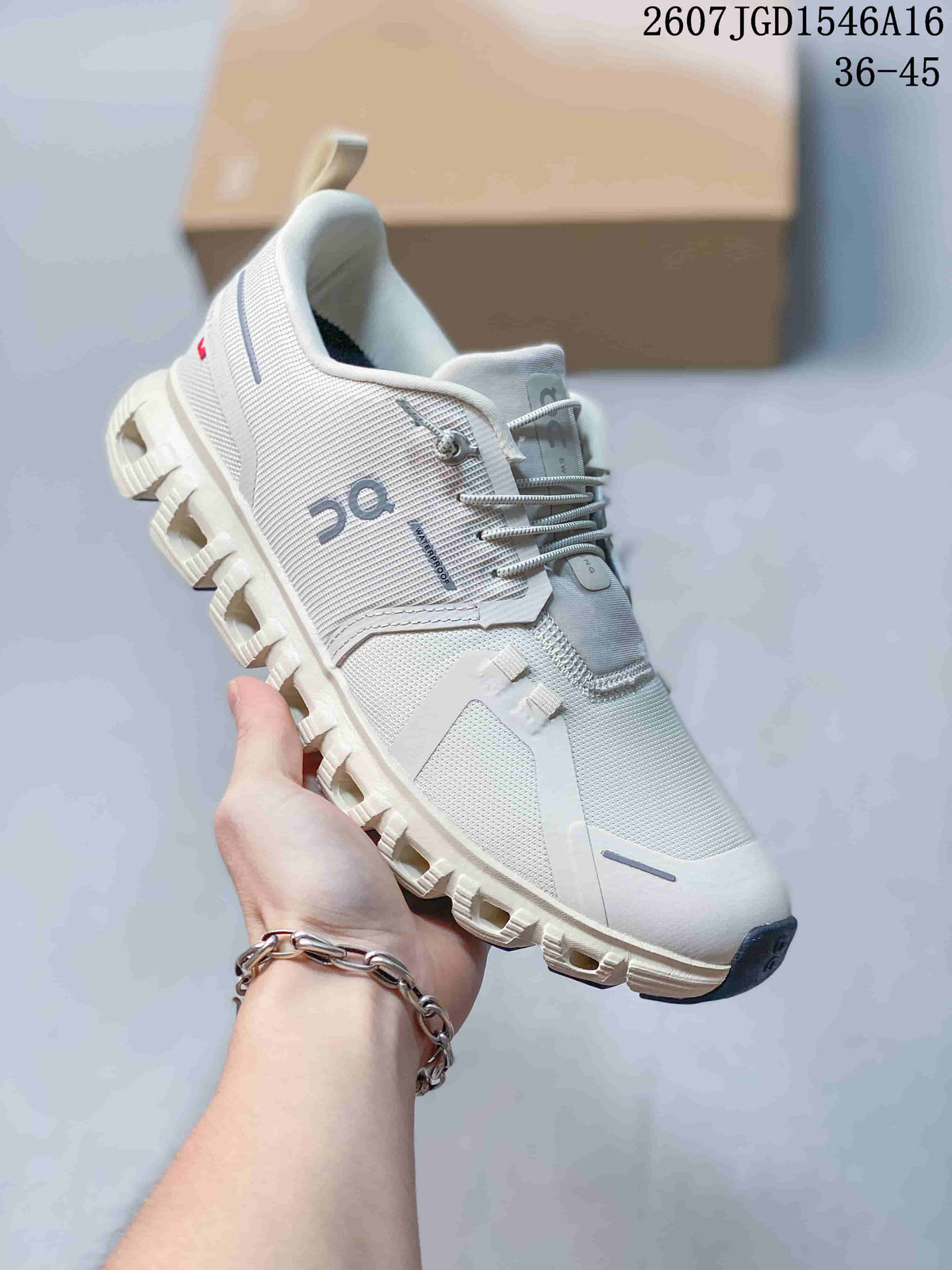 Angled side view of the white and grey On sneaker with visible branding, lace system and segmented outsole.