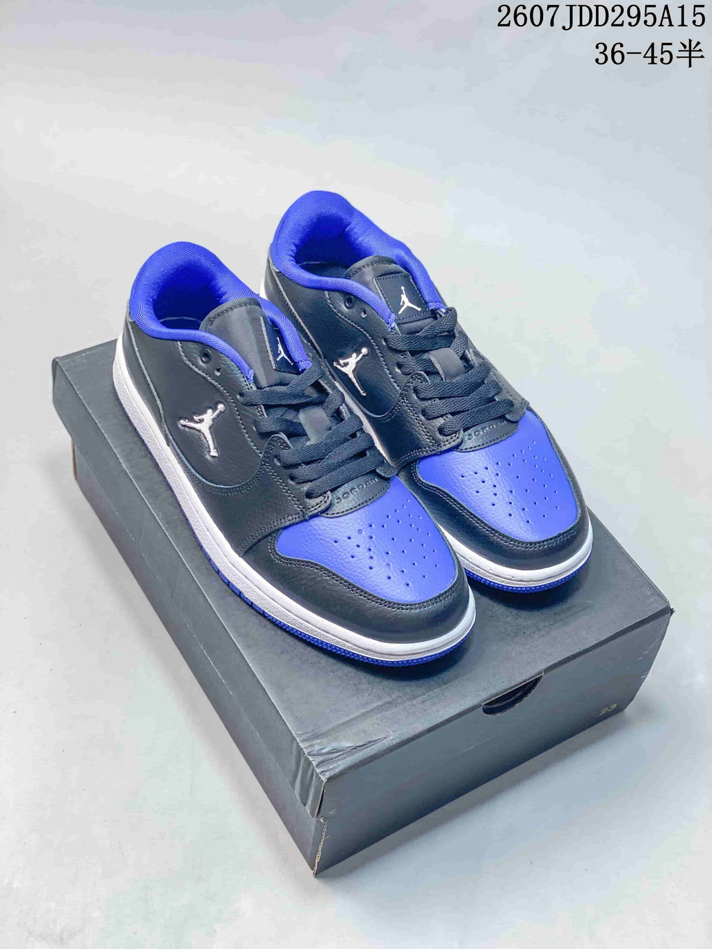Pair of black and blue low-top Jordan sneakers displayed on a shoe box, with style code 2607JDD295A15 and size range 36–45 shown above.