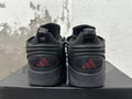 Rear view of black Adidas sneakers with red logo details and sculpted soles