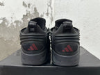 Rear view of black Adidas sneakers with red logo details and sculpted soles