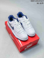 Pair of white and navy Nike SB Dunk Low Pro sneakers displayed on a red shoebox.