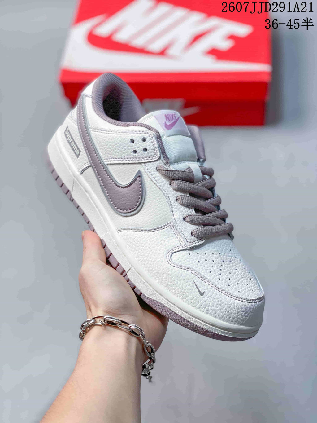 Three-quarter side view highlighting the white upper, gray Swoosh, gray laces, perforated toe box, and layered outsole.