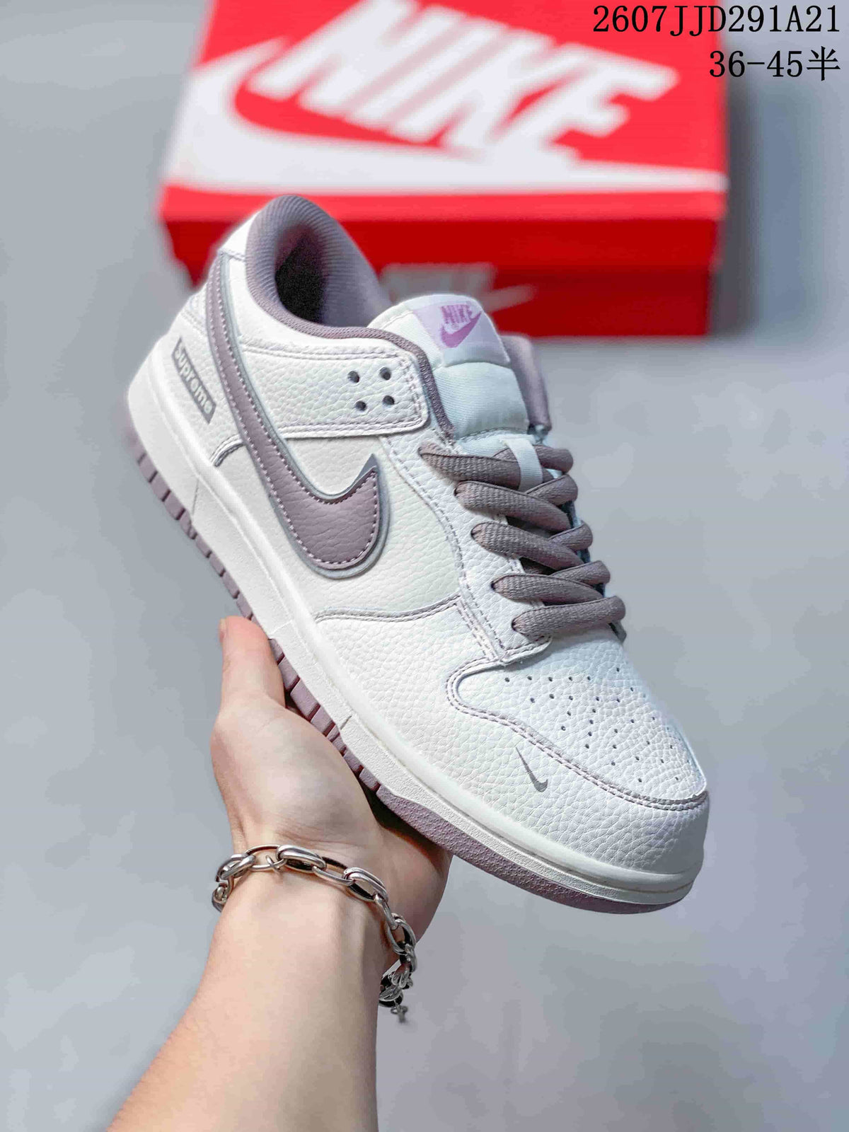 Three-quarter side view highlighting the white upper, gray Swoosh, gray laces, perforated toe box, and layered outsole.