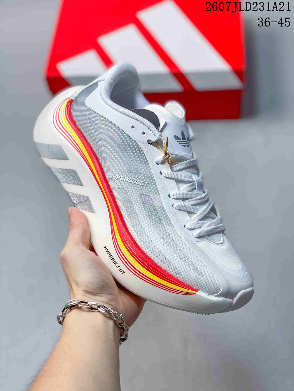 Angled side view showing Hyperboost branding, grey mesh-like panels, and red and yellow accent stripes.