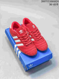 Red adidas Taekwondo sneakers with white side stripes displayed on a blue adidas shoe box.