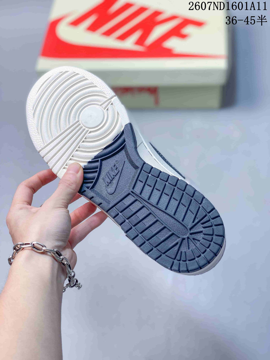 Close-up of the sneaker outsole showing a white and navy tread pattern with Nike branding.