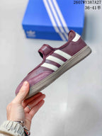 Side view highlighting the burgundy upper, white three-stripe design, Mary Jane strap, and textured outsole.