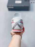 Rear view showing the white heel, pink heel trim, layered side detailing and textured outsole.