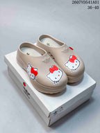 Beige adidas x Hello Kitty mule clogs with red bow details shown on a branded box