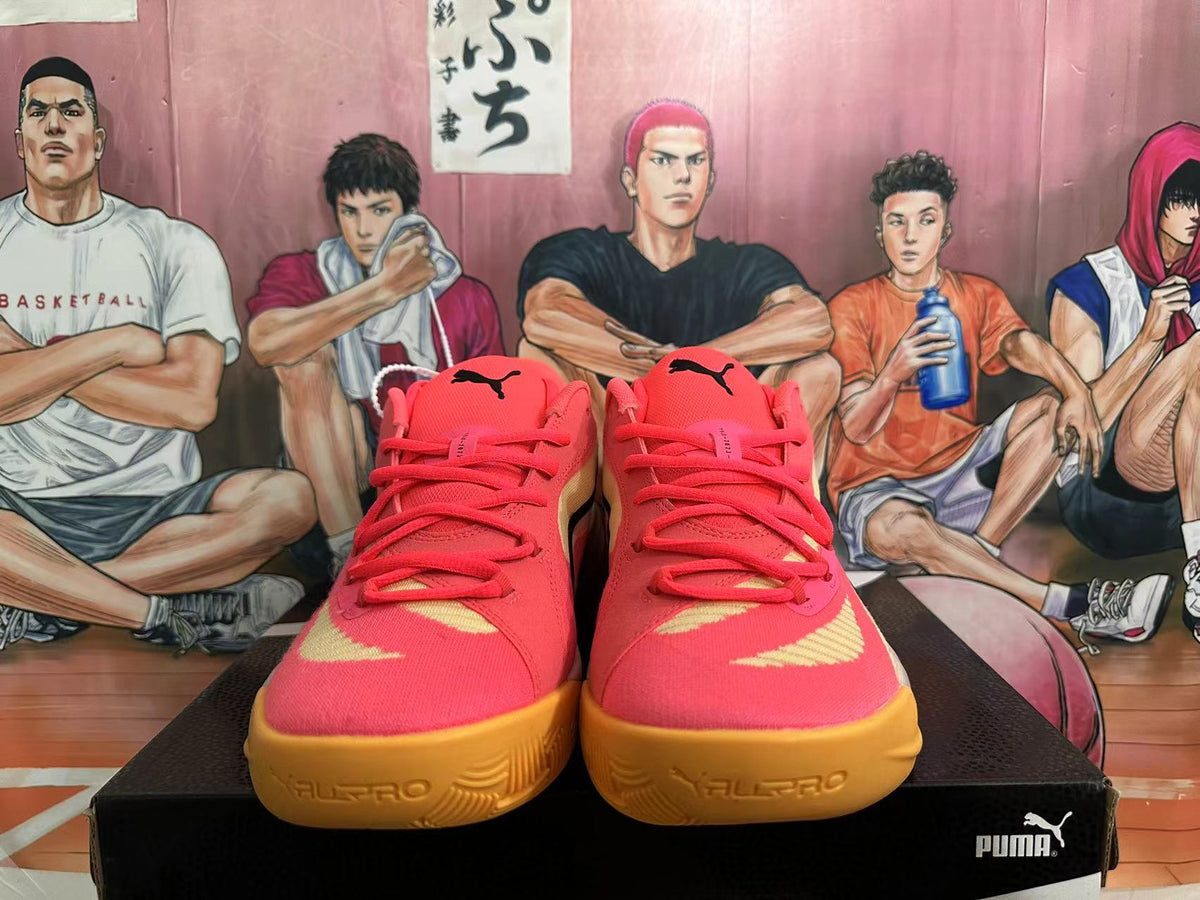 Front view of coral pink PUMA All-Pro basketball shoes with gold-tone outsoles.