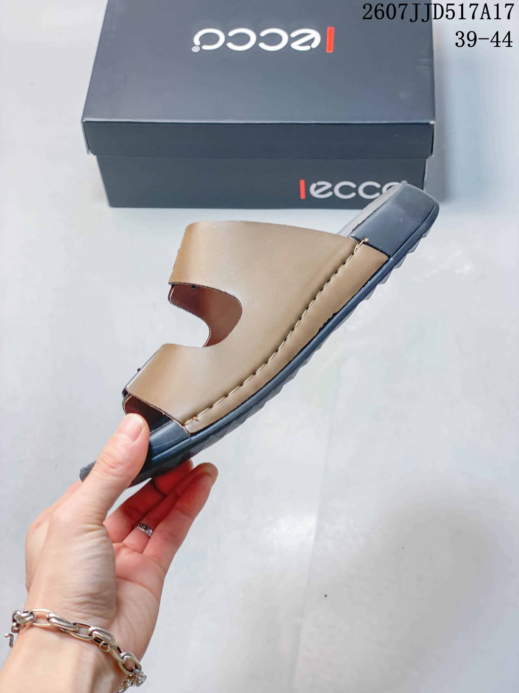 Side view of the brown and black sandal showing the layered upper and dark outsole.