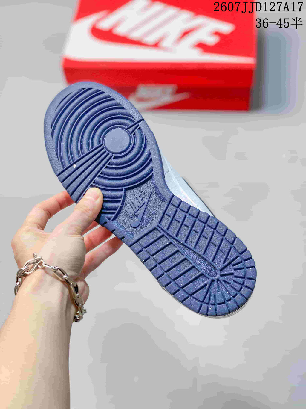 Close view of the navy rubber outsole showing circular and grid traction patterns.