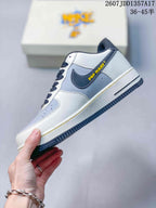 Side profile showing the white and gray panel layout, dark Swoosh, yellow side accent, and textured outsole.