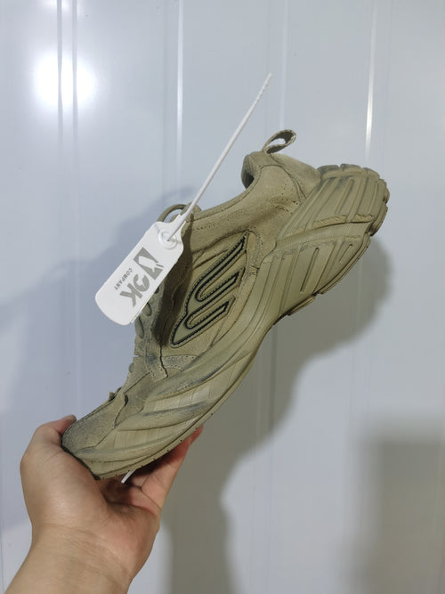 Side view of a beige 3K Company 9090 sneaker showing the chunky sole, layered upper, heel pull tab, and outlined side detail.