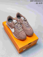 Light brown Nike Classic Cortez sneakers with white Swoosh details displayed on an orange shoebox.