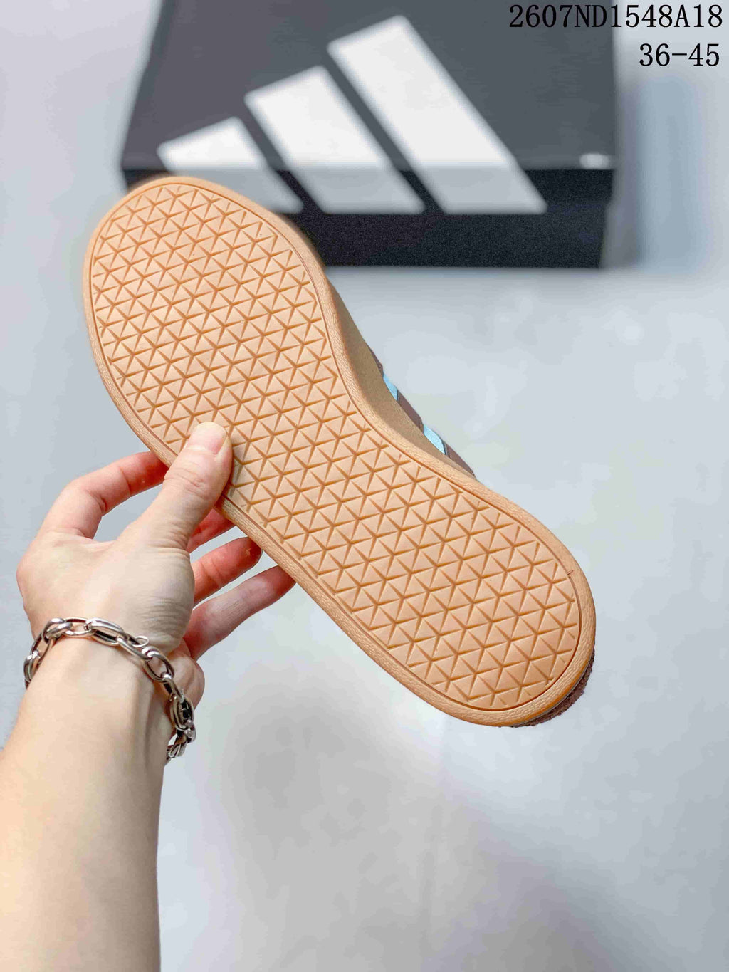 Close view of the textured gum-colored outsole with repeating geometric tread.