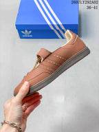 Side view of the brown sneaker showing perforated detailing, stitched panels, cream lining, and the textured outsole.