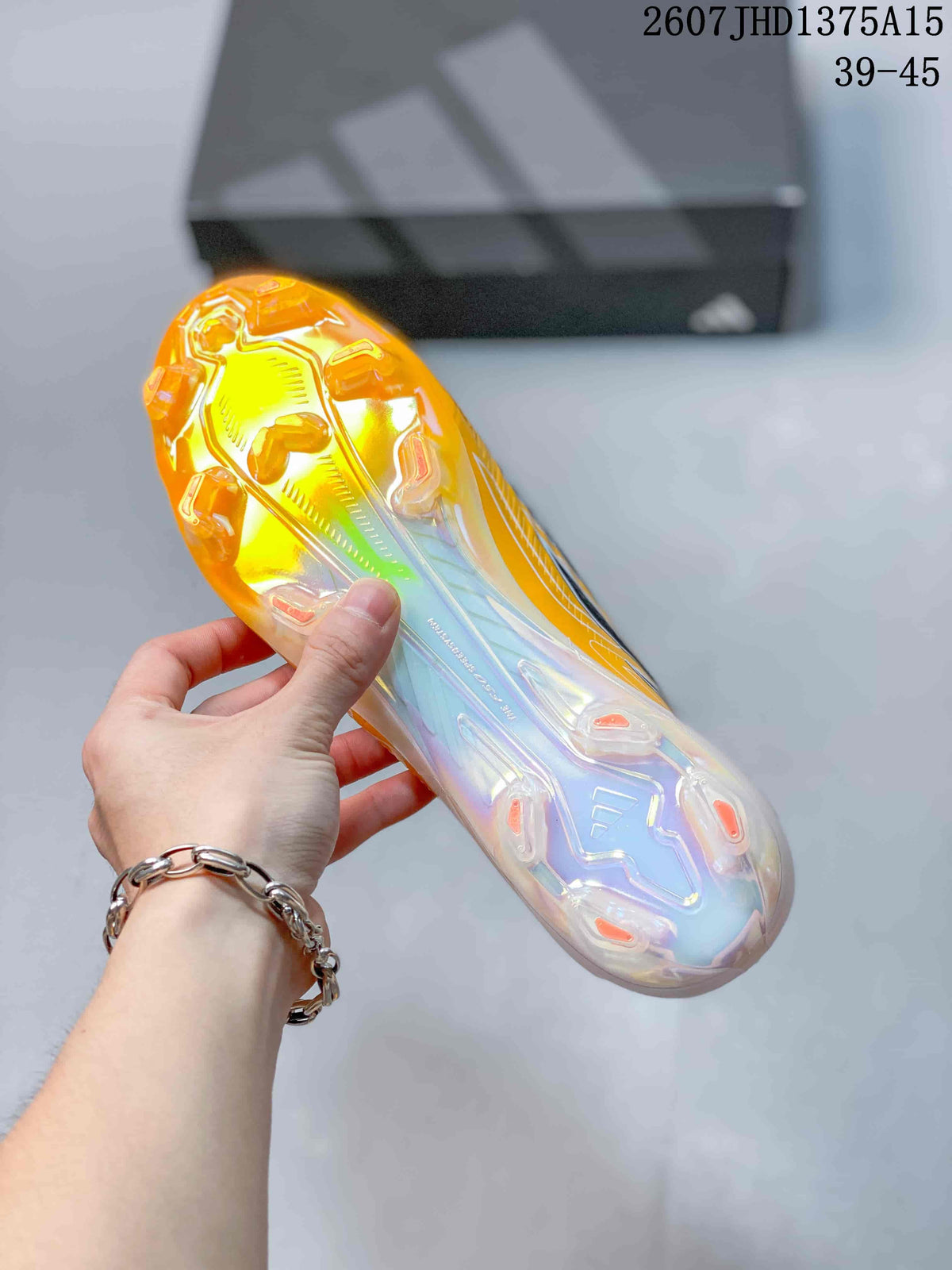 Close view of the translucent molded stud outsole with orange and iridescent details.