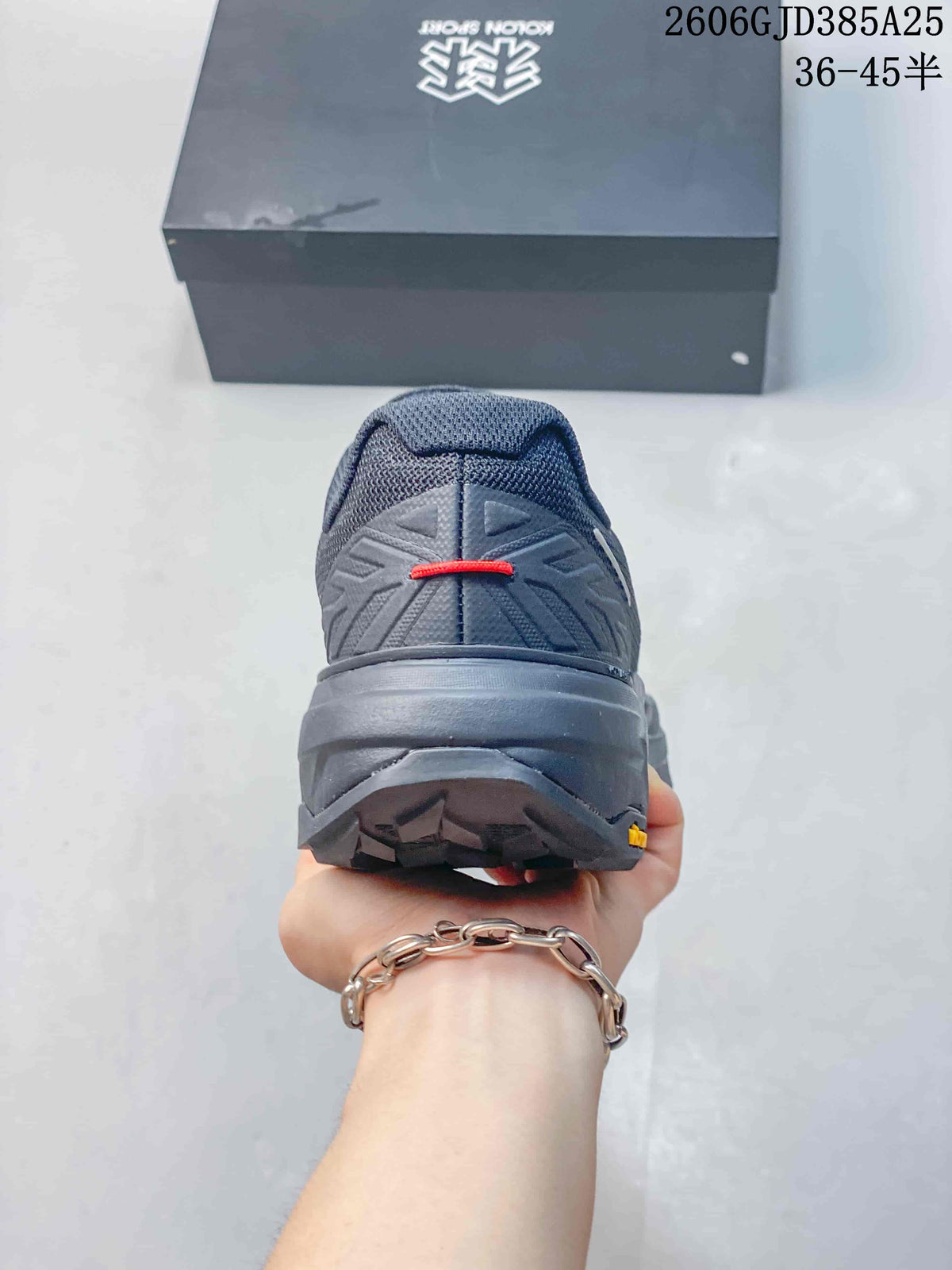 Rear view showing the heel construction and lugged outsole of the charcoal shoe.