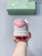 Rear view of the sneaker showing a pink heel panel, white upper, Jordan Wings-style branding, and pink outsole details.