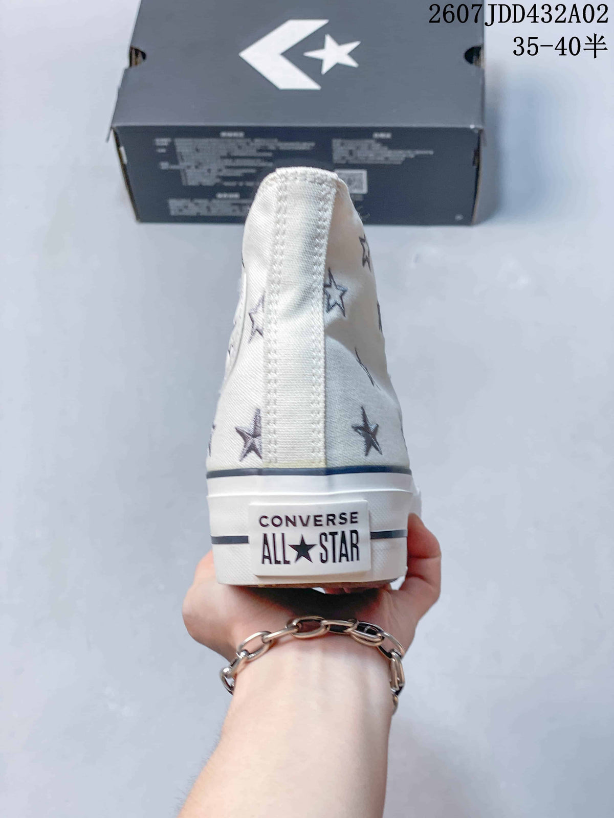 Rear view of the cream high-top sneaker with embroidered stars and Converse All Star heel branding.