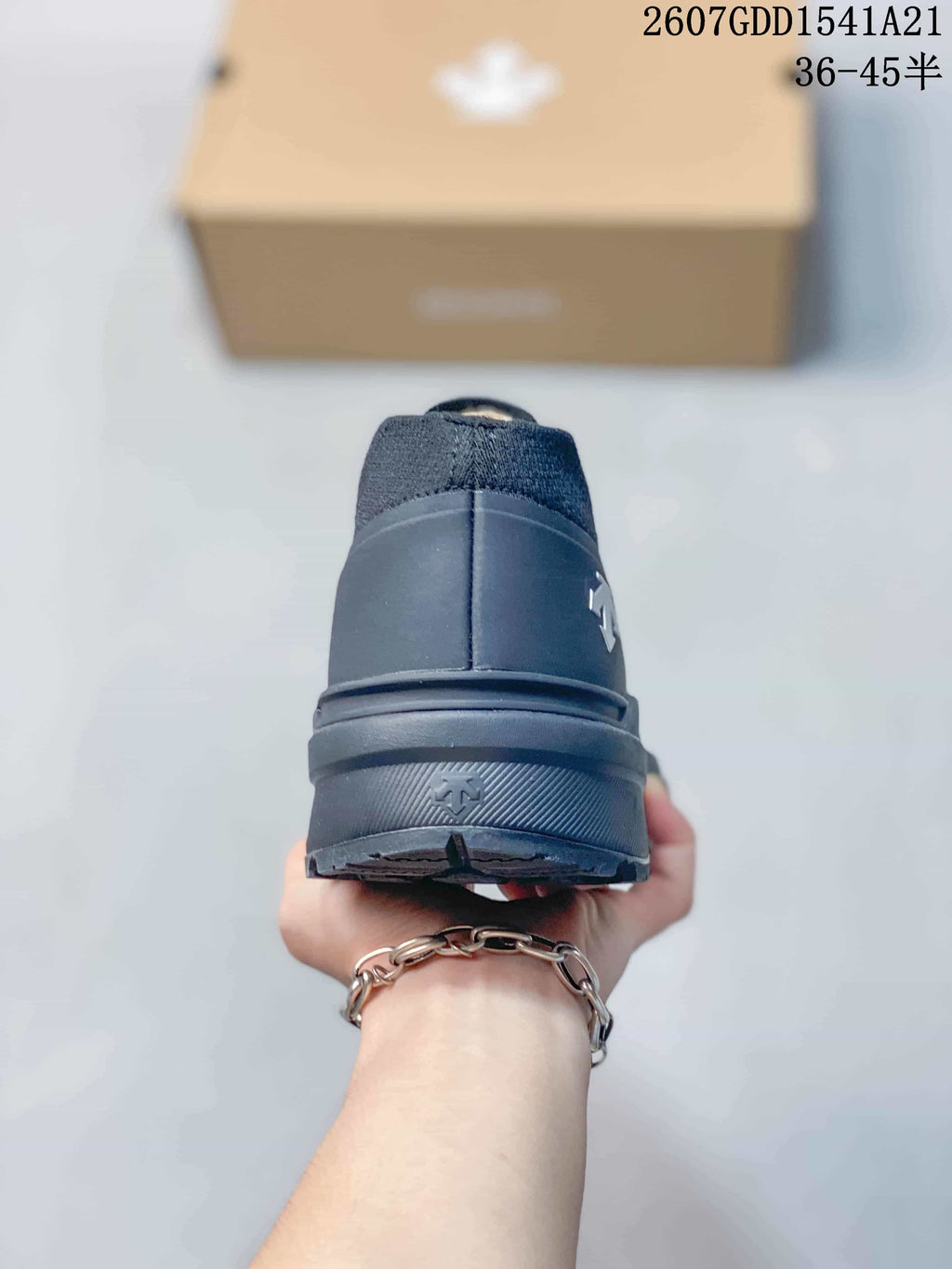 Rear view of the dark sneaker showing the heel counter, pull area, and outsole.