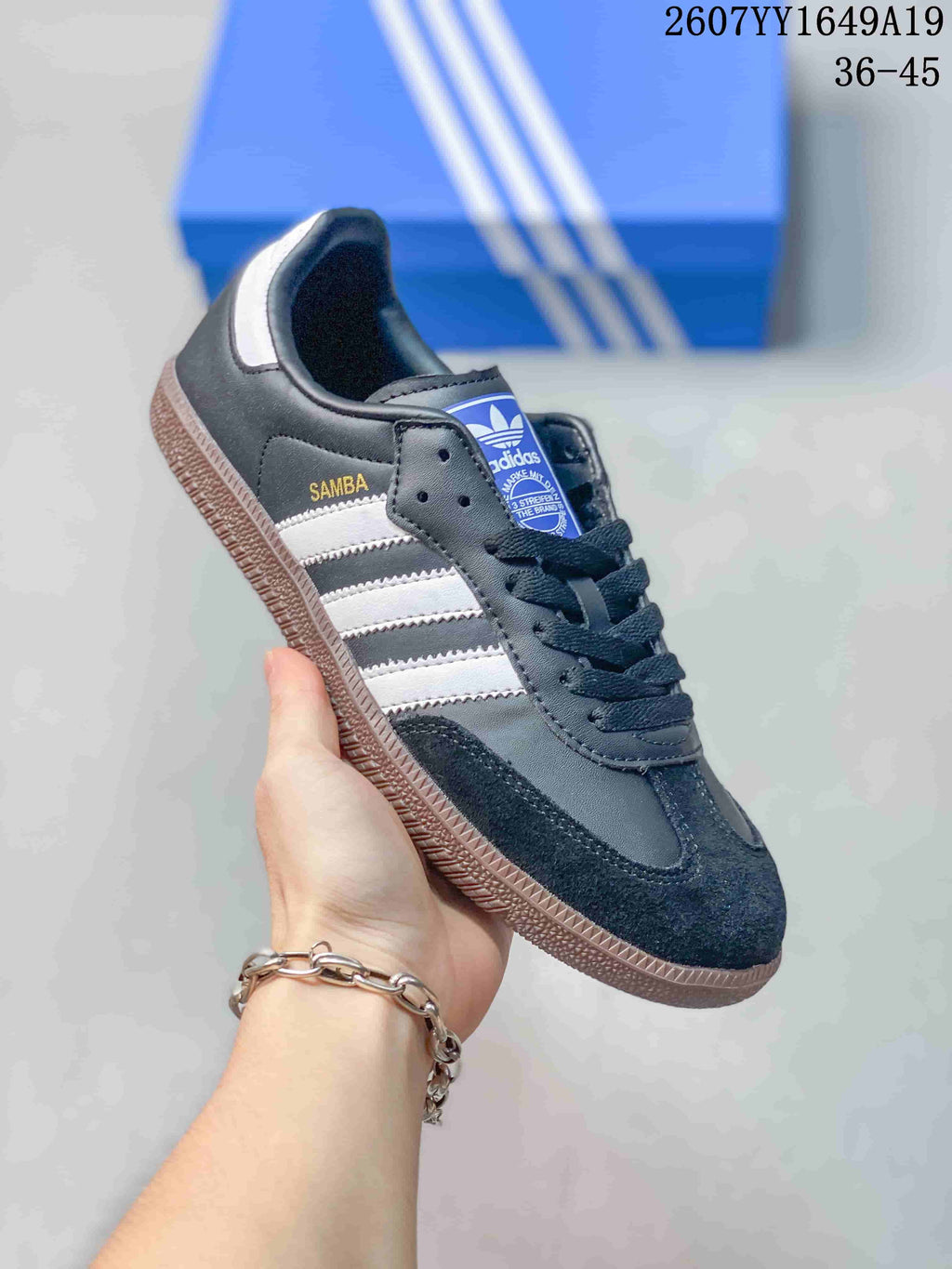 Close side view of a black Adidas Samba sneaker with white stripes and a gum-colored outsole.