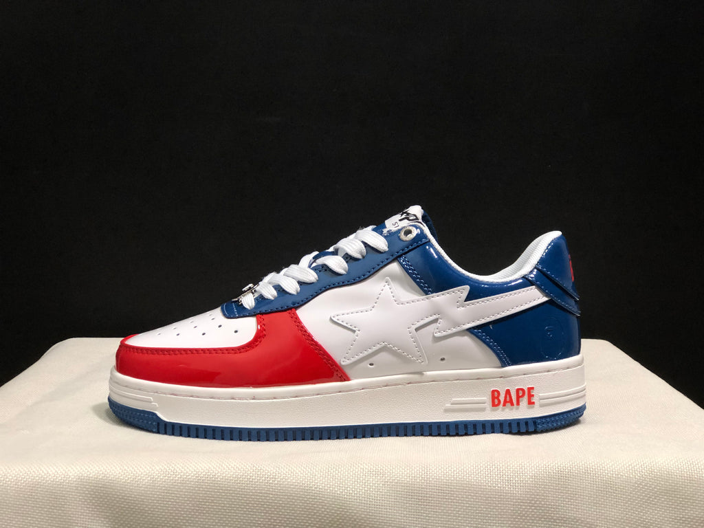Side view of a white, blue, and red Bape Sta low-top sneaker with a star-shaped side motif.
