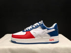 Side view of a white, blue, and red Bape Sta low-top sneaker with a star-shaped side motif.