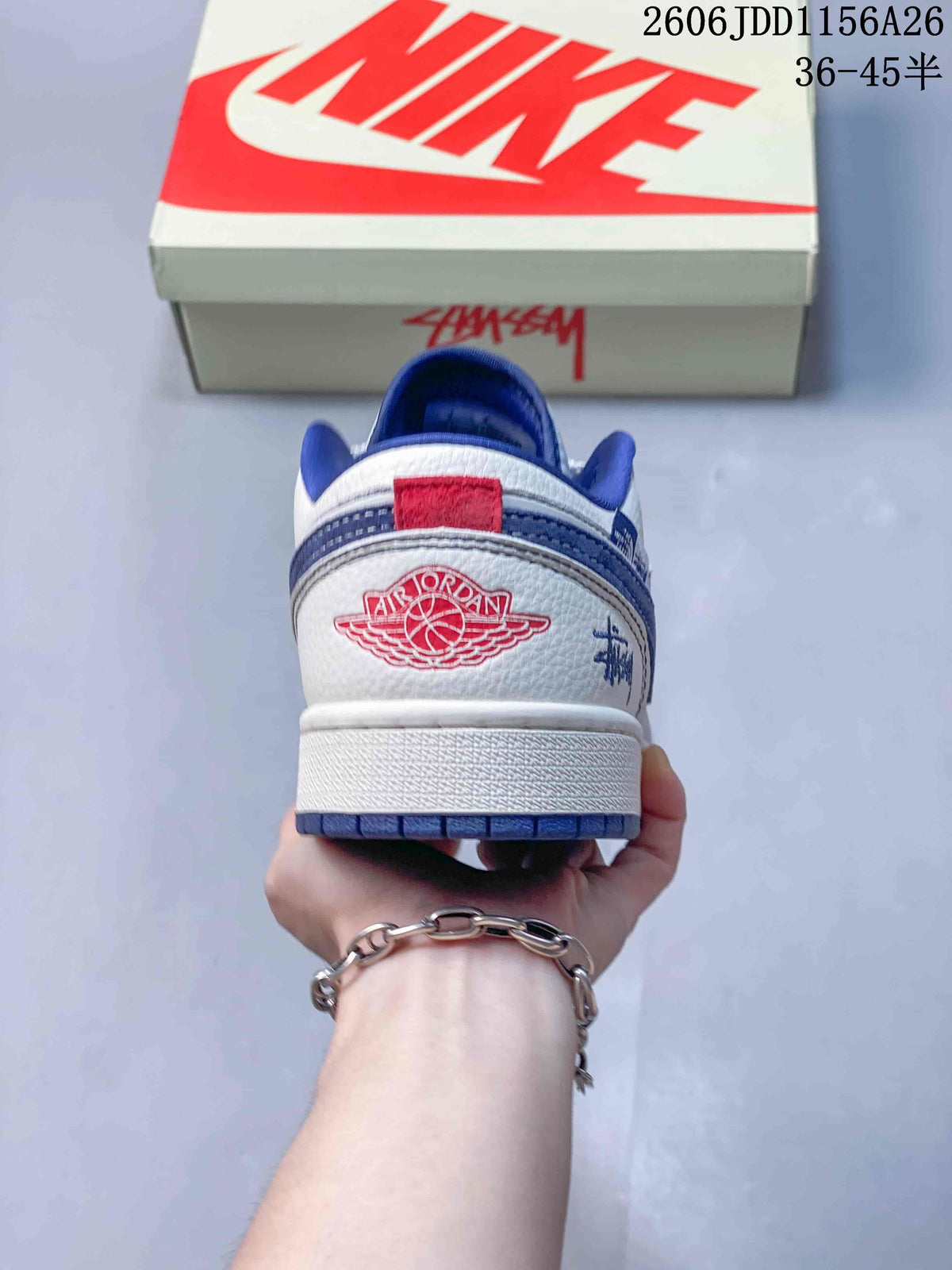 Rear view of the sneaker showing the white heel panel, red-and-blue Jordan Wings-style emblem, blue outsole, and side graphic detail.