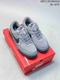 Pair of gray Nike Terra Manta Suede sneakers displayed on a red Nike shoebox.